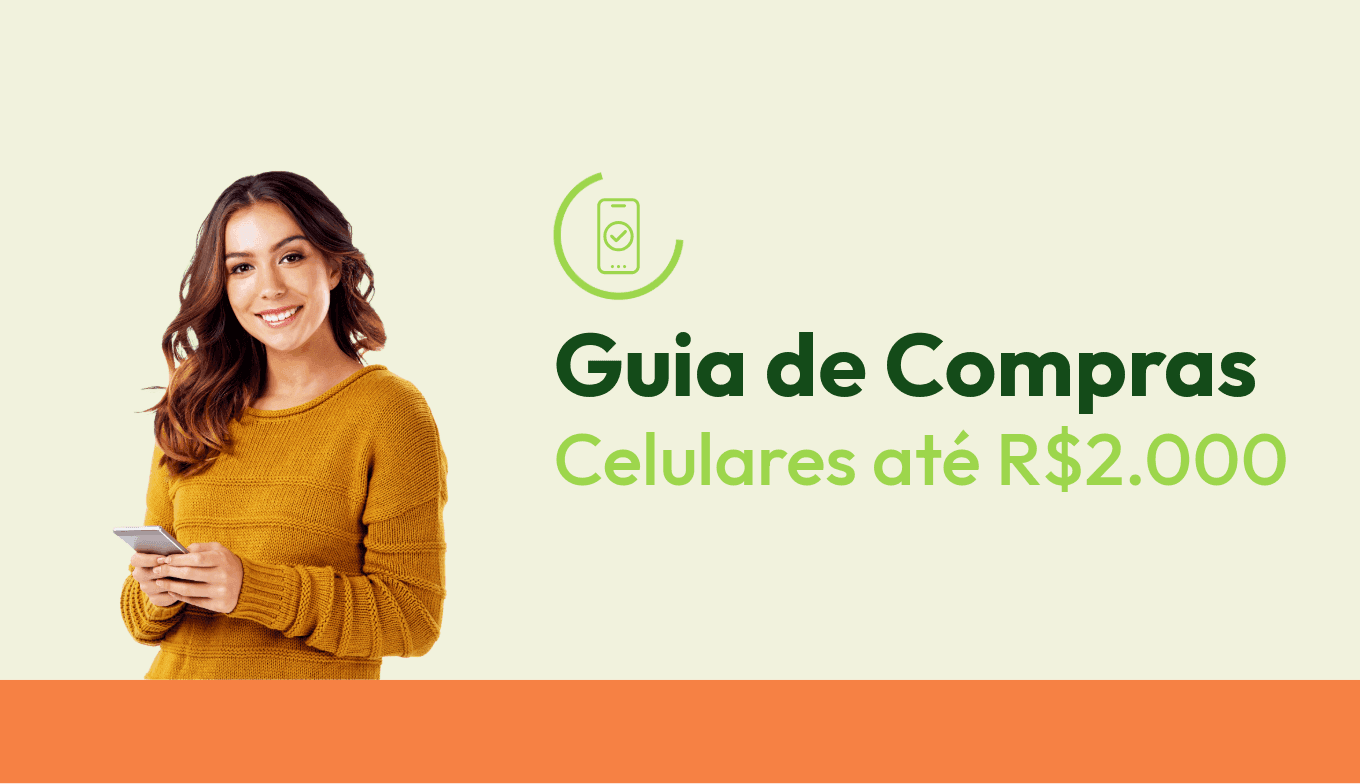 Mulher branca sorridente com um celular na mão, usando uma blusa laranja.